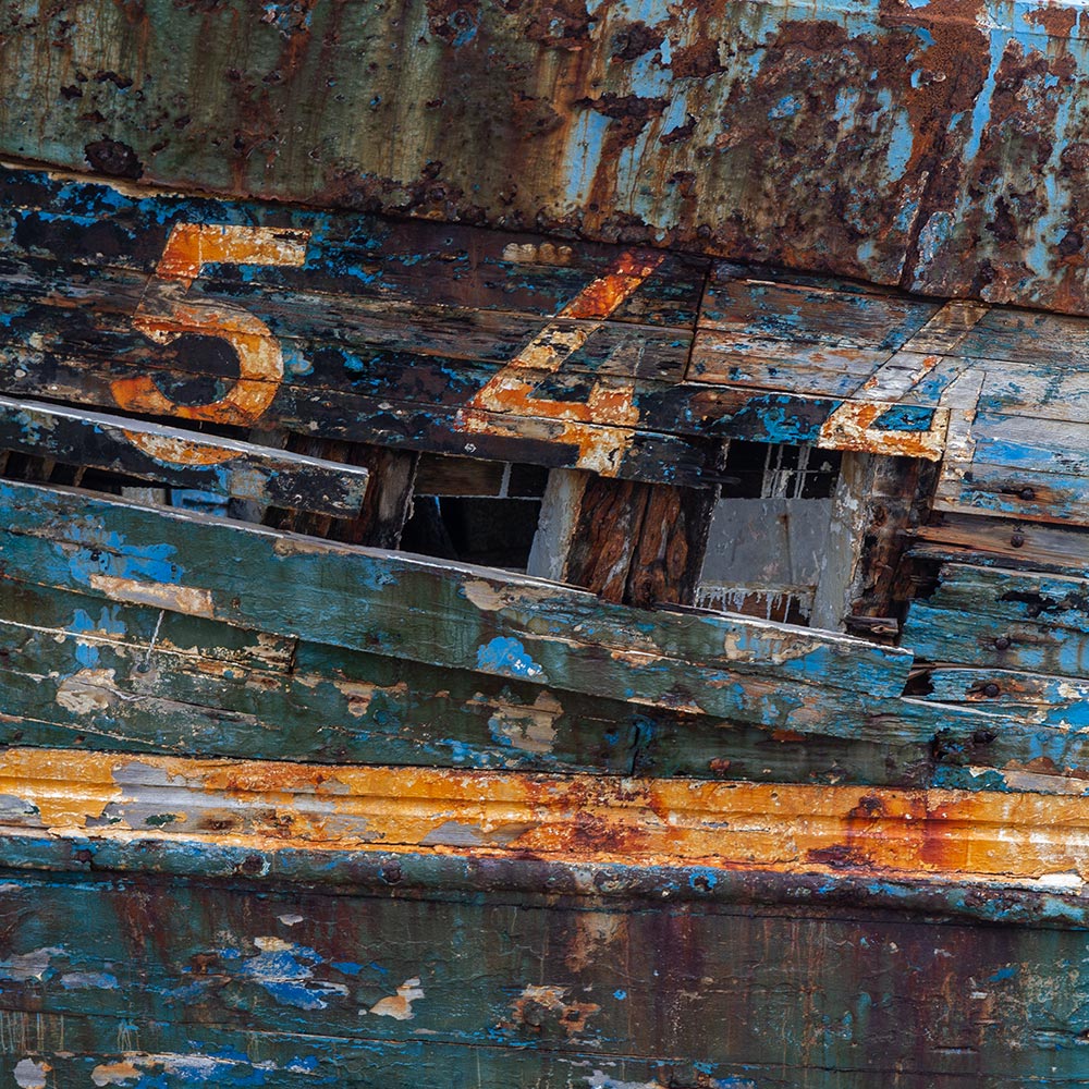 Camaret-sur_mer | The registration number 544 on side of a rotting hulk of a fishing boat with peeling rusty blue, and yellow paint