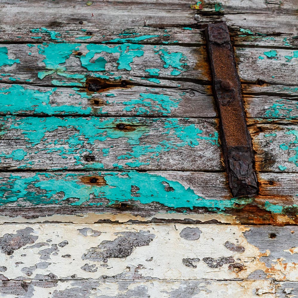 Camaret-sur_mer | The rusty steel shroud fixing plate on side of a rotting hulk of a fishing boat with peeling rusty turquoise cyan paint